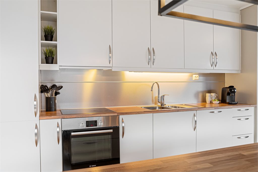 Kjøkkenet har flott innredning med hvite fronter og integrerte hvitevarer.