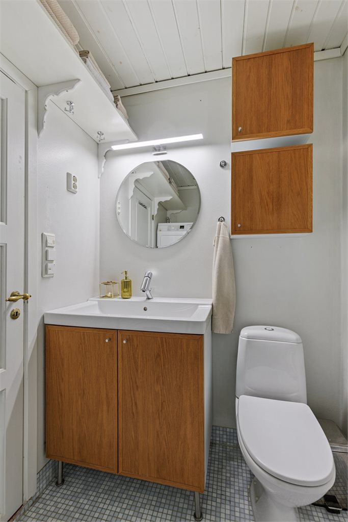 Innredning i treutførelse er en flott kontrast mot det ellers lyse badet. 