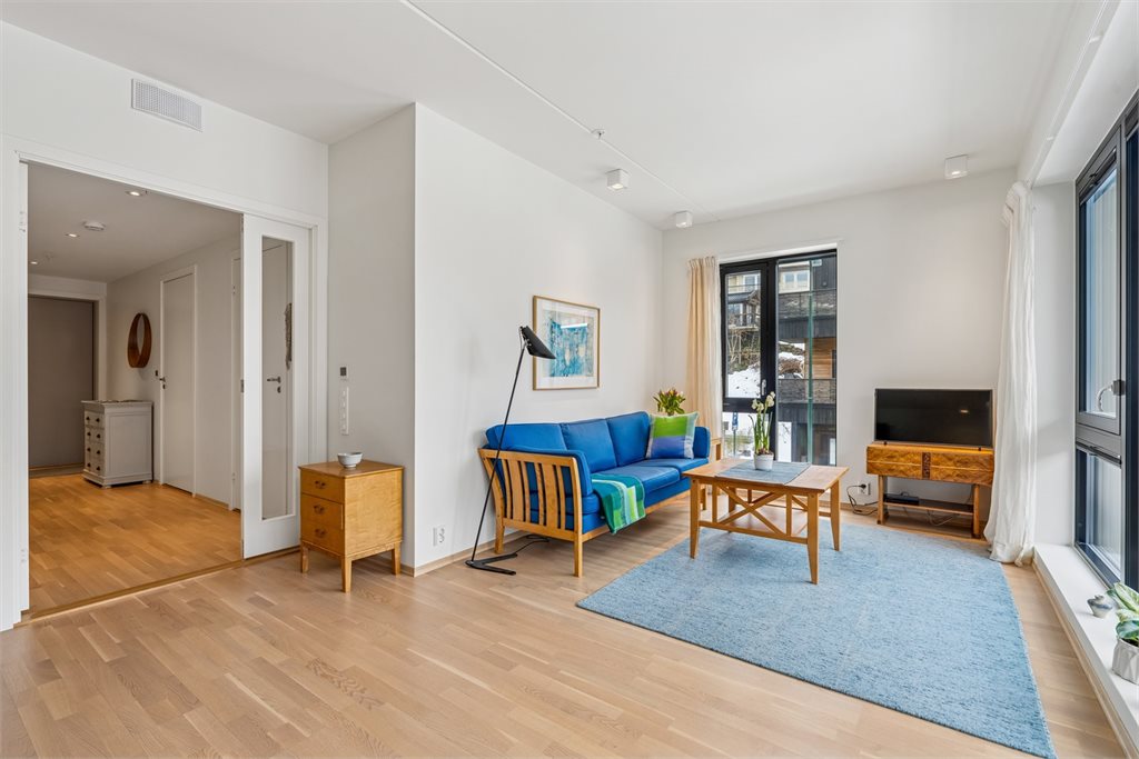 God plass til sofagruppe og tv-møblement. Utgang til lun balkong.