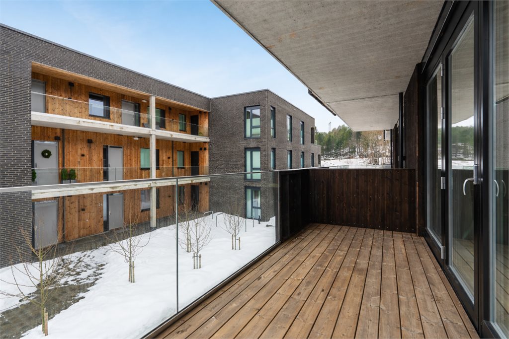 Overbygget balkong med plass til sittegruppe – en hyggelig forlengelse av stuen.