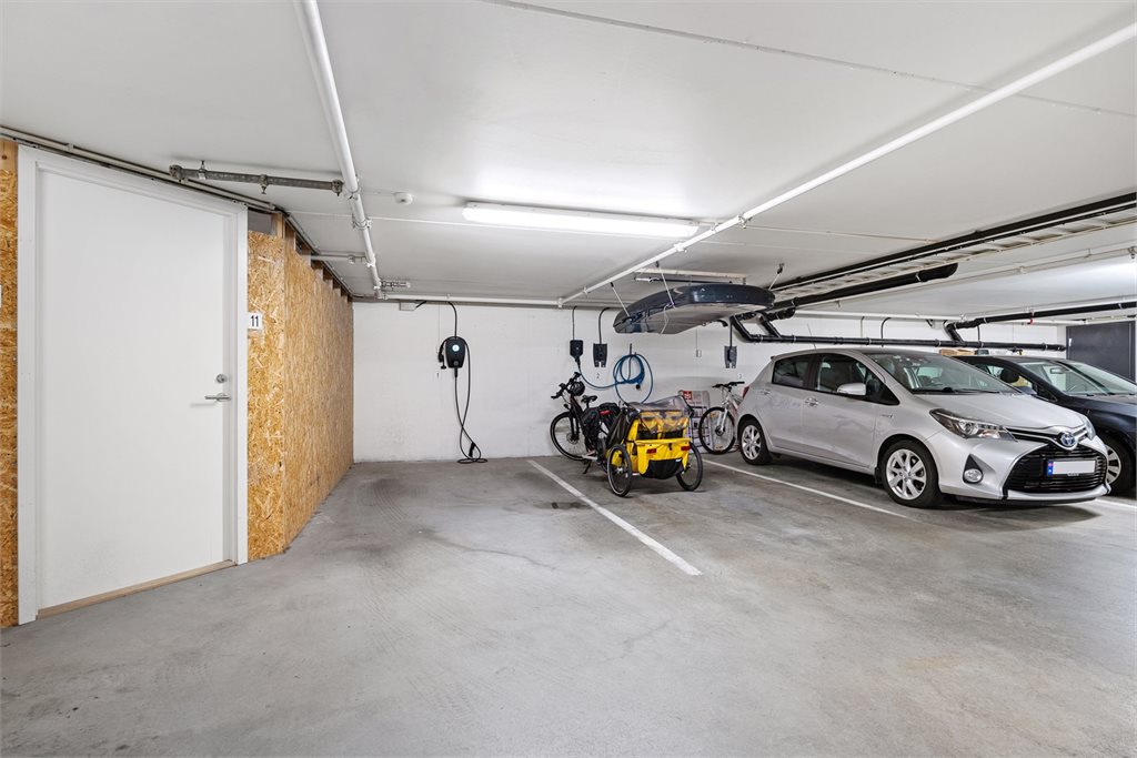 Det må nevnes at det er godt med oppbevaring i bod i kjeller like ved parkeringsplassen. Det er også montert elbillader, samt elektrisk port inn til felles garasje. 