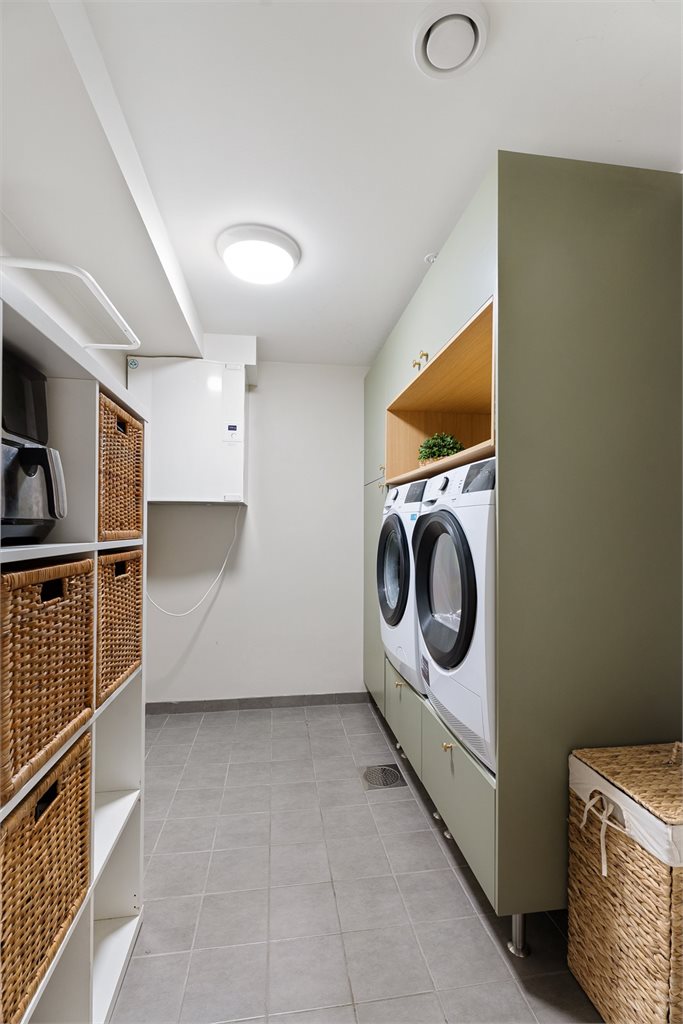 Videre er det inngang til eget separat vaskerom med flott og moderne innredning fra 2025. 