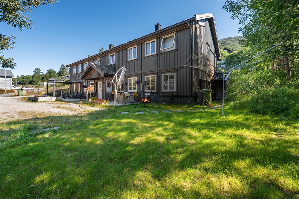 Fasadebilde som viser boligens skjermede plassering i rolige omgivelser
