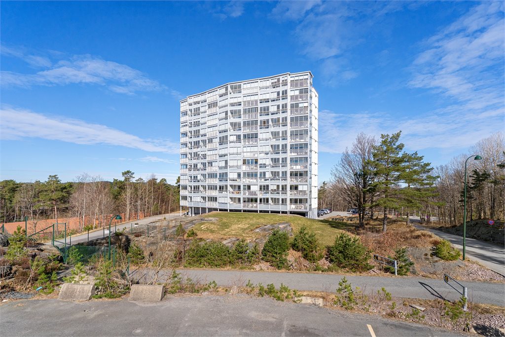 Fasade av bygget med grønt og åpent nærområde.