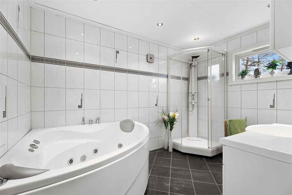 Flislagt bad med boblebad og dusjkabinett
