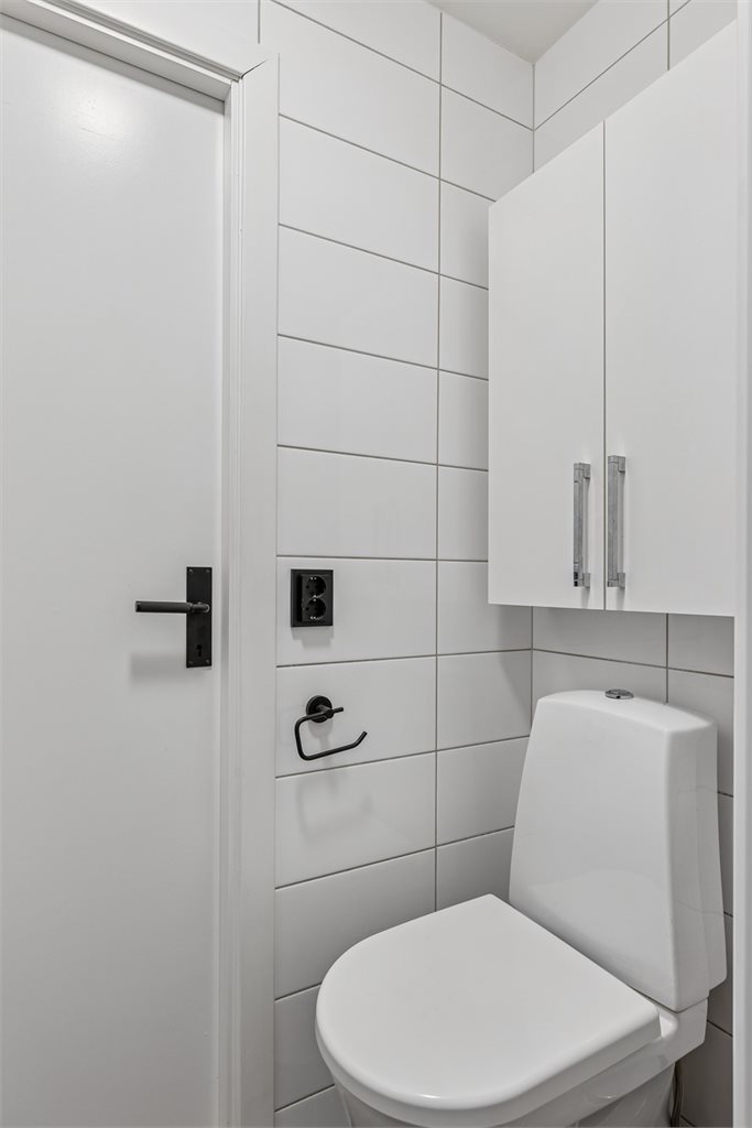 Leilighetens bad er helfliset, sorte detaljer går igjen på hele badet og skaper en moderne helhet. 