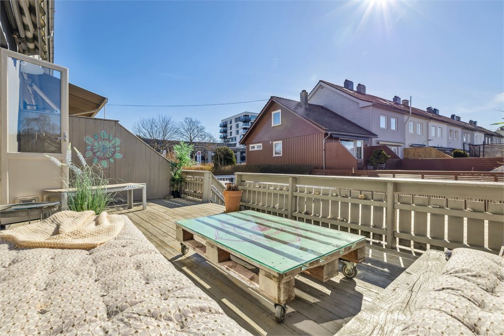 Terrasse med god plass til både sittegruppe og grill – en naturlig forlengelse av stuen.