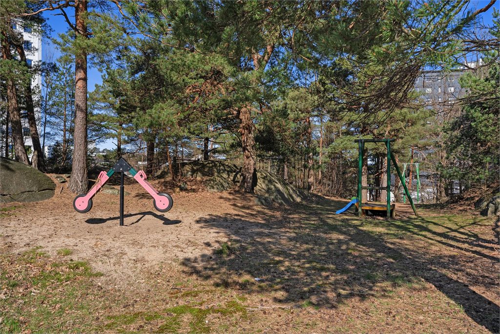 Barnevennlig fellesomra°de med lekeapparater og natur rundt