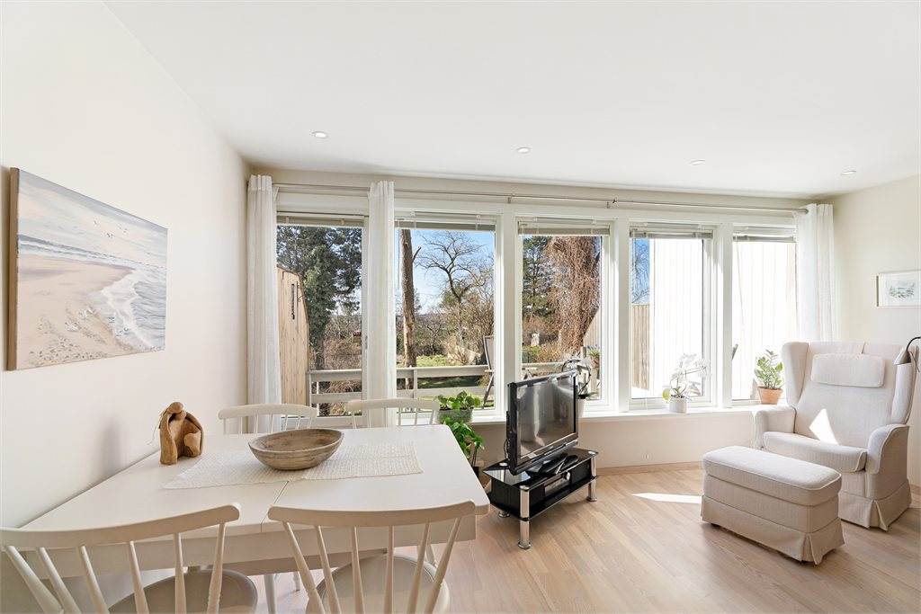 Lys og luftig stue med store vindusflater og hyggelig spiseplass med utsikt