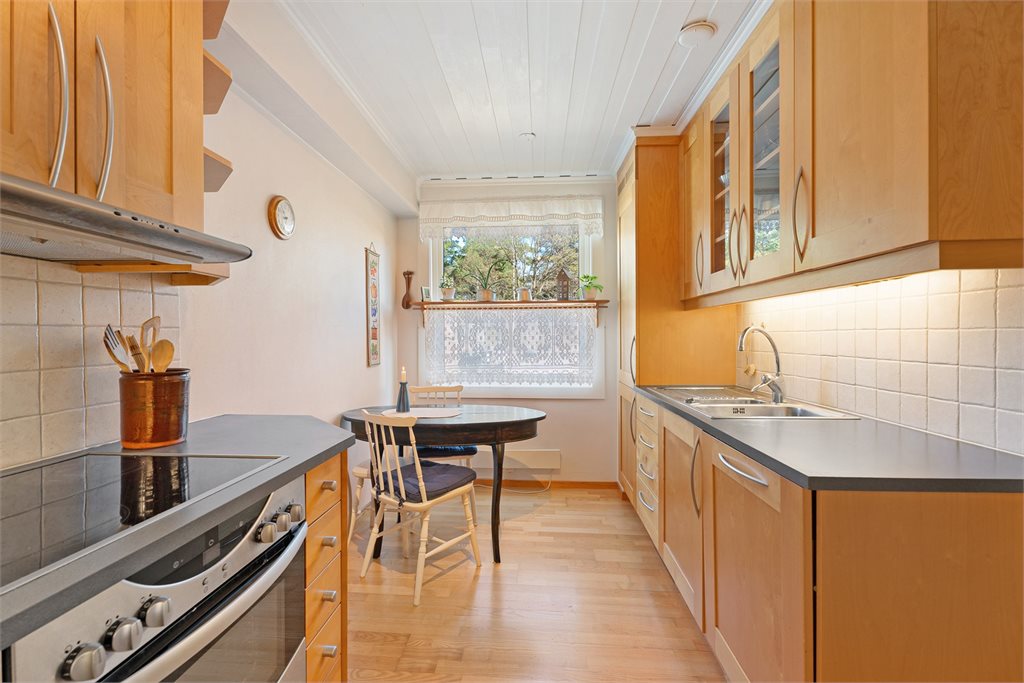 Lyst og funksjonelt kjøkken med god skapplass og spiseplass ved vindu