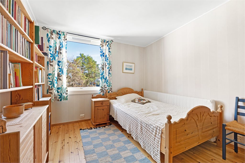 Romslig soverom med tregulv med godt lys