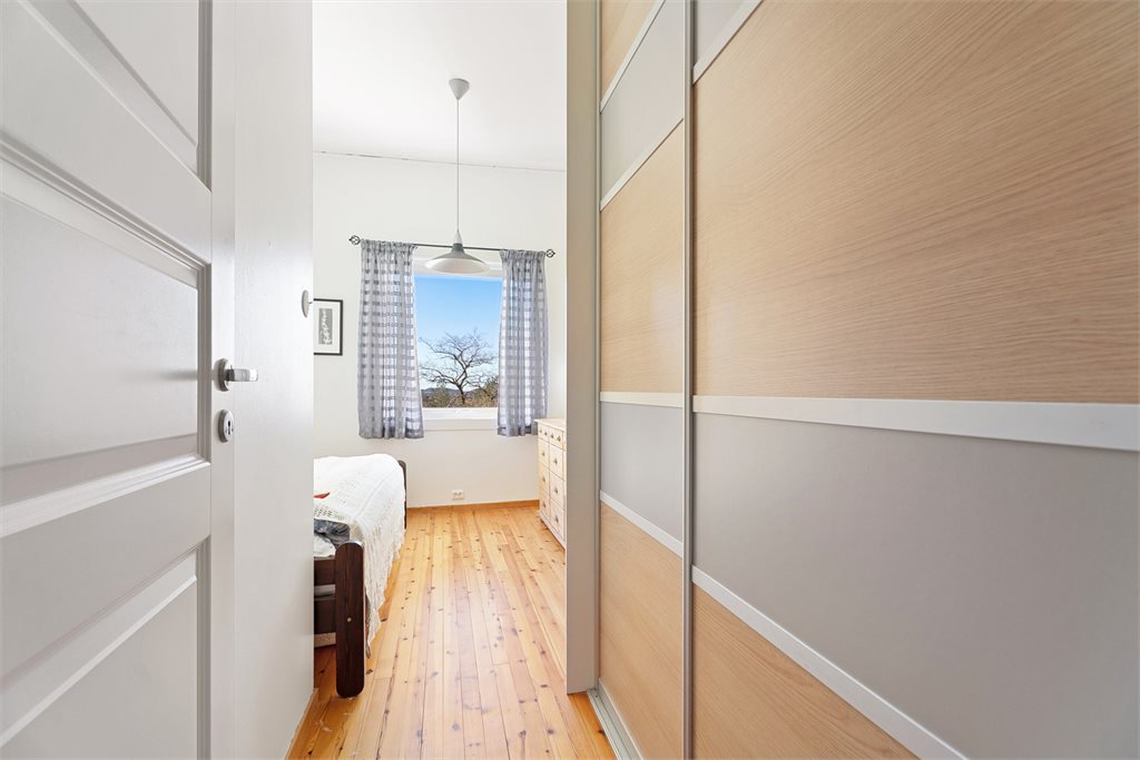 Soverom med tregulv og praktisk skyvedørsgarderobe