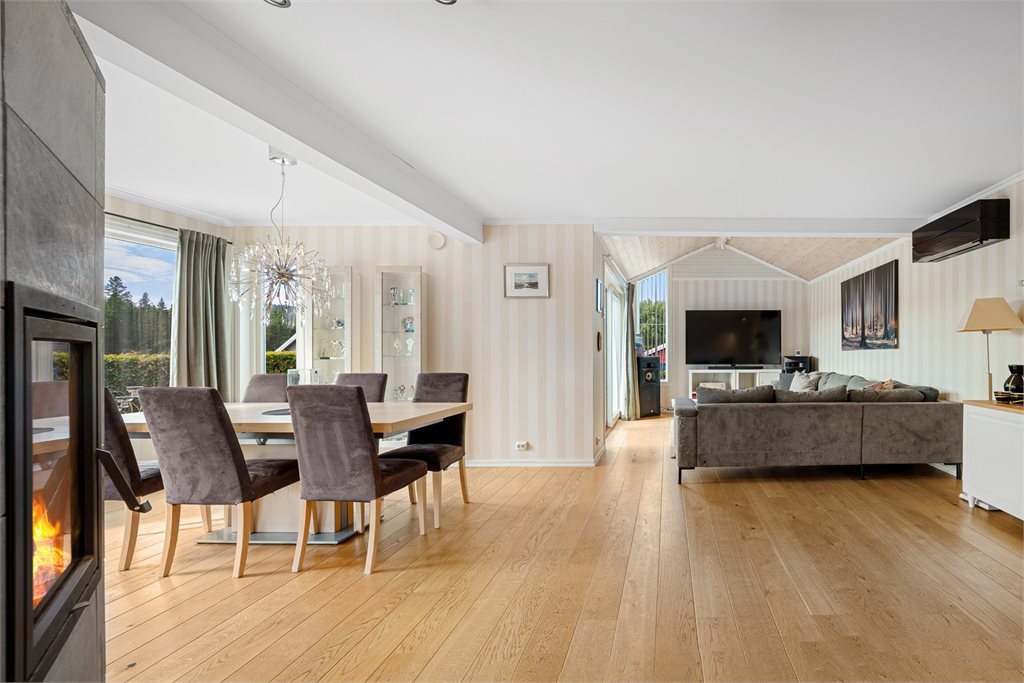 Velkommen inn i stuen. Her blir du møtt av en lun peis som både skaper en hyggelig atmosfære og bidrar med god varme til hele etasjen.