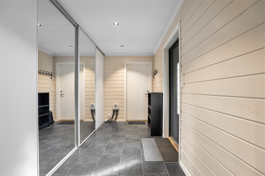 Velkommen inn! Flislagt entré med varmekabler i gulvet og praktisk skyvedørsgarderobe med god oppbevaringsplass for jakker og sko.