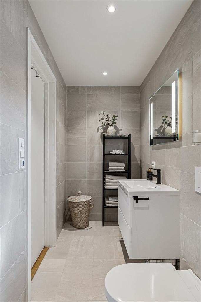 Delikat flislagt baderom med moderne innredning.