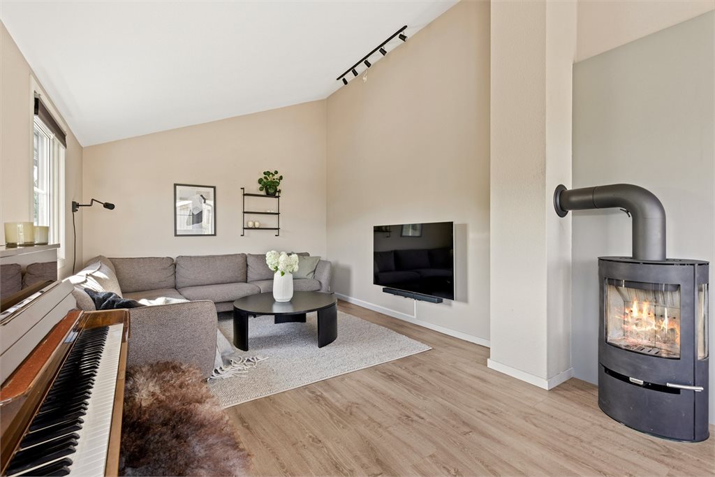 Lys, pen og romslig stue med generøs takhøyde.