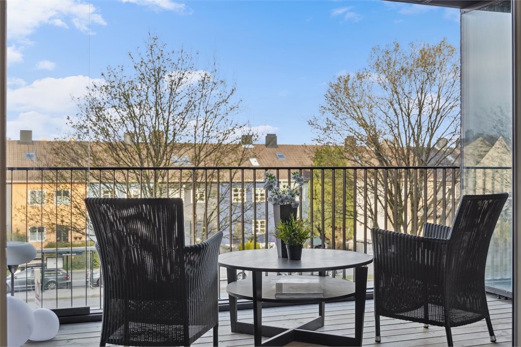 Stor innglasset balkong med ettermiddagssol.
