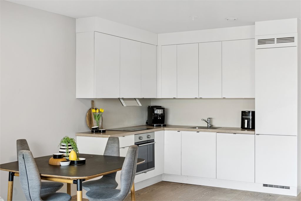 Kjøkkenet er innredet med praktisk form i åpning mot stuen, som gjør rommet sosialt ved besøk.