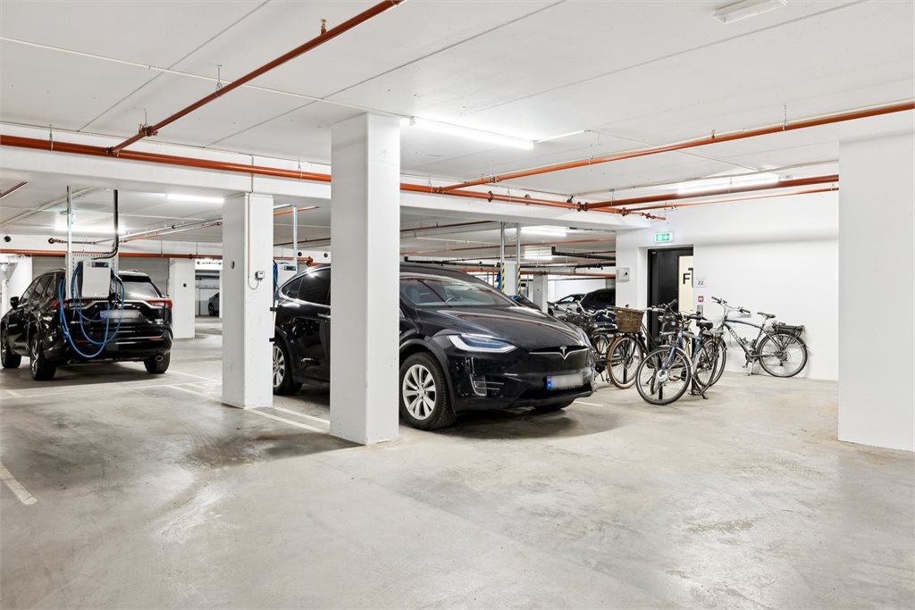 Egen parkering like ved inngangen i kjeller. Med elbil lader.