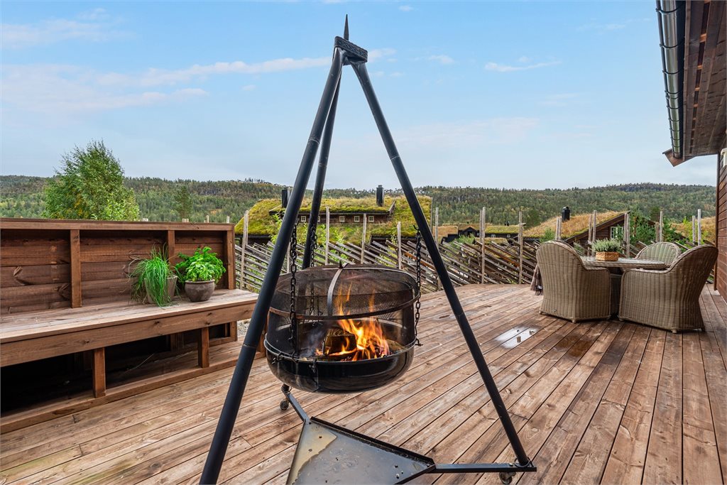 Skjermet terrassehjørne med plass til bålpanne og hyggelige kvelder rundt varmen.