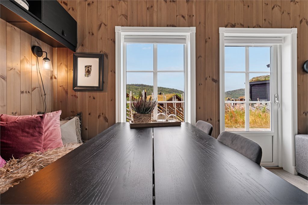 Hyggelig spiseplass ved vinduet med utsyn mot omgivelsene.