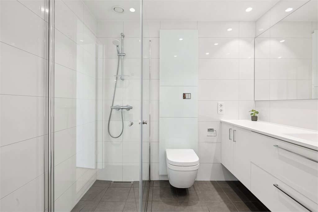 Lyst og delikat baderom, flislagt.