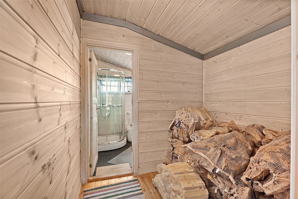 Praktisk bod med god plass til ved – lett tilgjengelig fra badet.