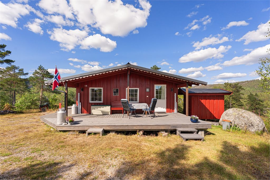 Hytta ligger usjenert og fint til i vakre naturomgivelser, med terrasse langs fasaden