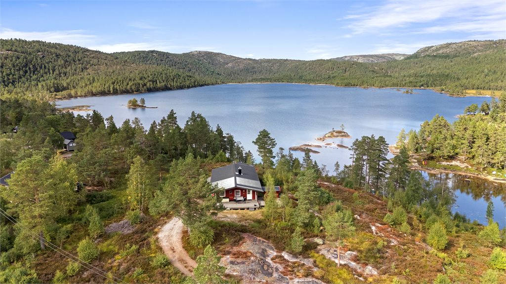 Hytta ligger flott til i terrenget med storslått utsikt over vannet og de omkringliggende skogsområdene.