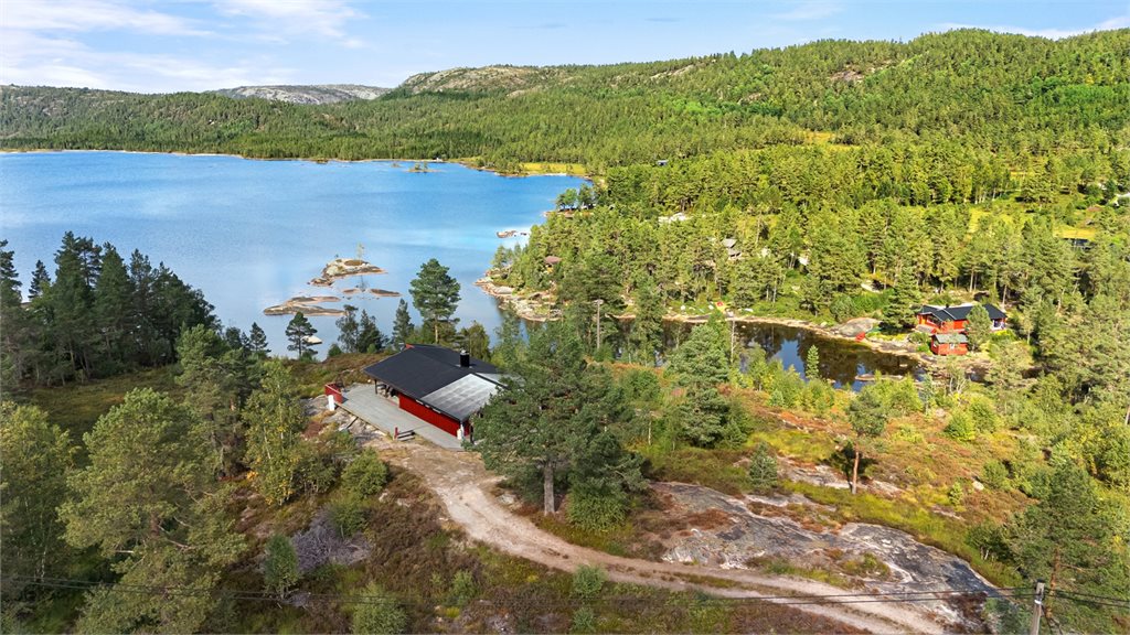 Luftfoto som viser den flotte beliggenheten med hytta høyt og fritt over vannet.