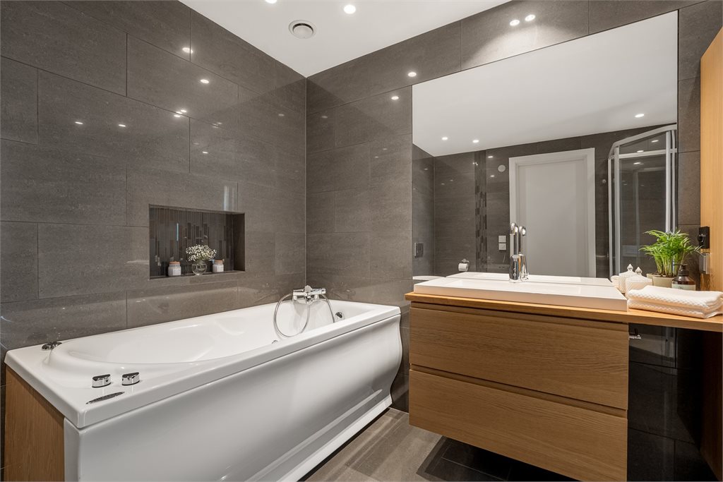 Delikat baderom med badekar og servant
