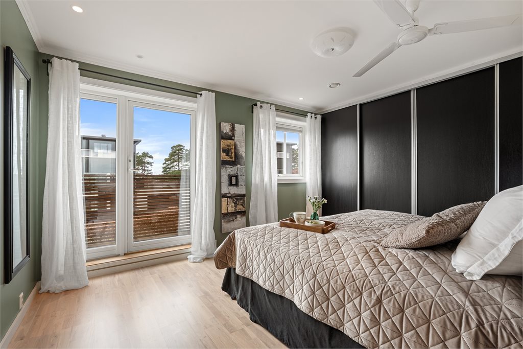 Soverom med utgang til terrasse og gode lysforhold. Stor skyvedørsgarderobe 
