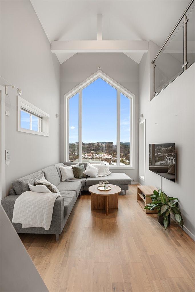 Stue med imponerende takhøyde og store vindusflater
