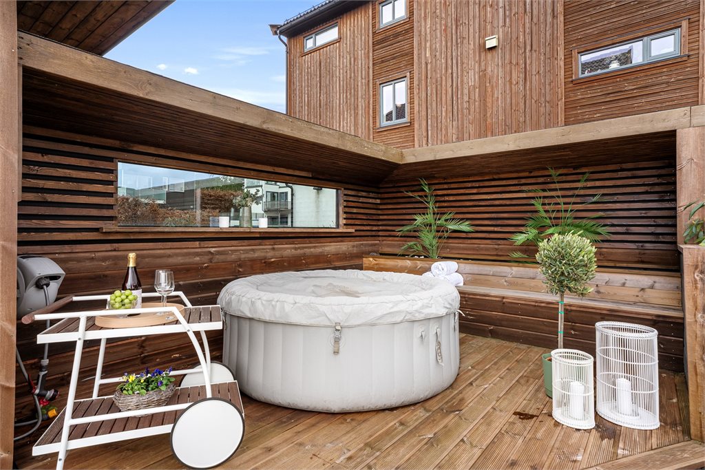 Skjermet uteplass med boblebad og levegger
