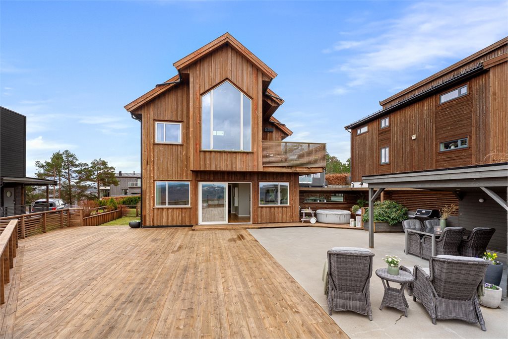 Moderne fasade med store vindusflater og utgang til terrasse
