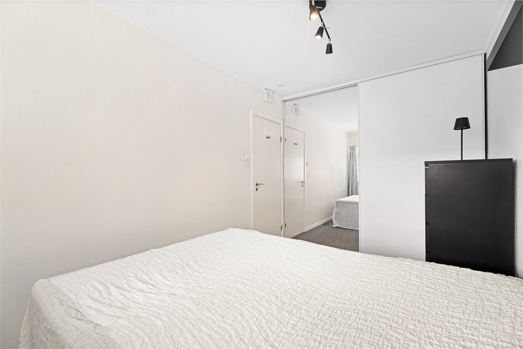 Stor skyvedørsgarderobe med speilfronter gir både oppbevaring og funksjonalitet.