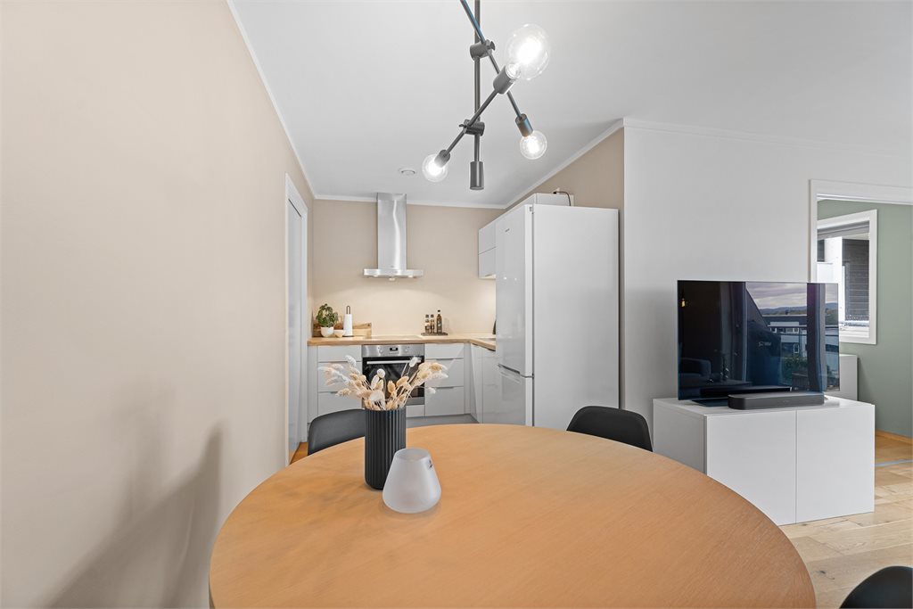 Kjøkkenet har en tidløs innredning med hvite fronter og heltre benkeplate 