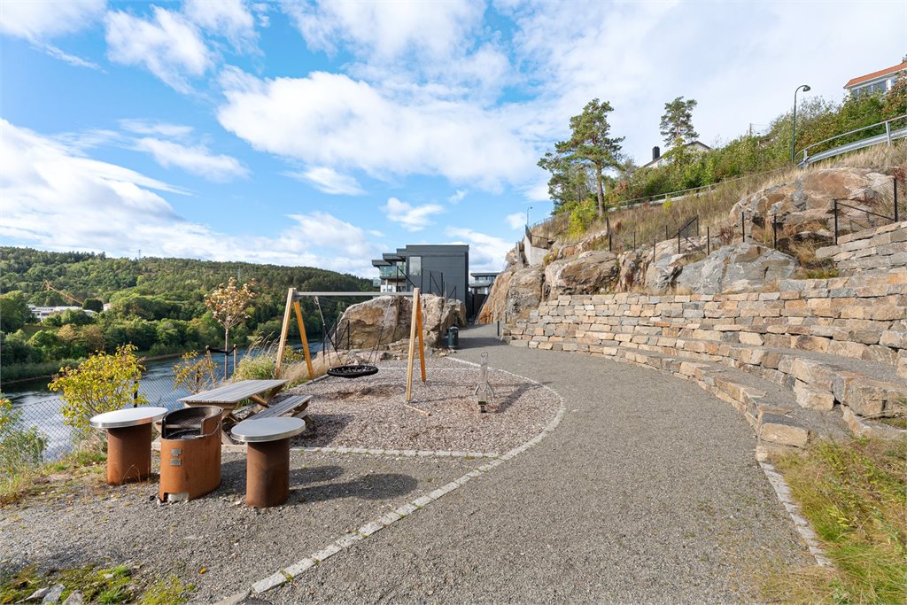 Felles uteområde med lekeplass, sitteplasser og grillmuligheter – lett tilgjengelig fra leilighetens etasje.