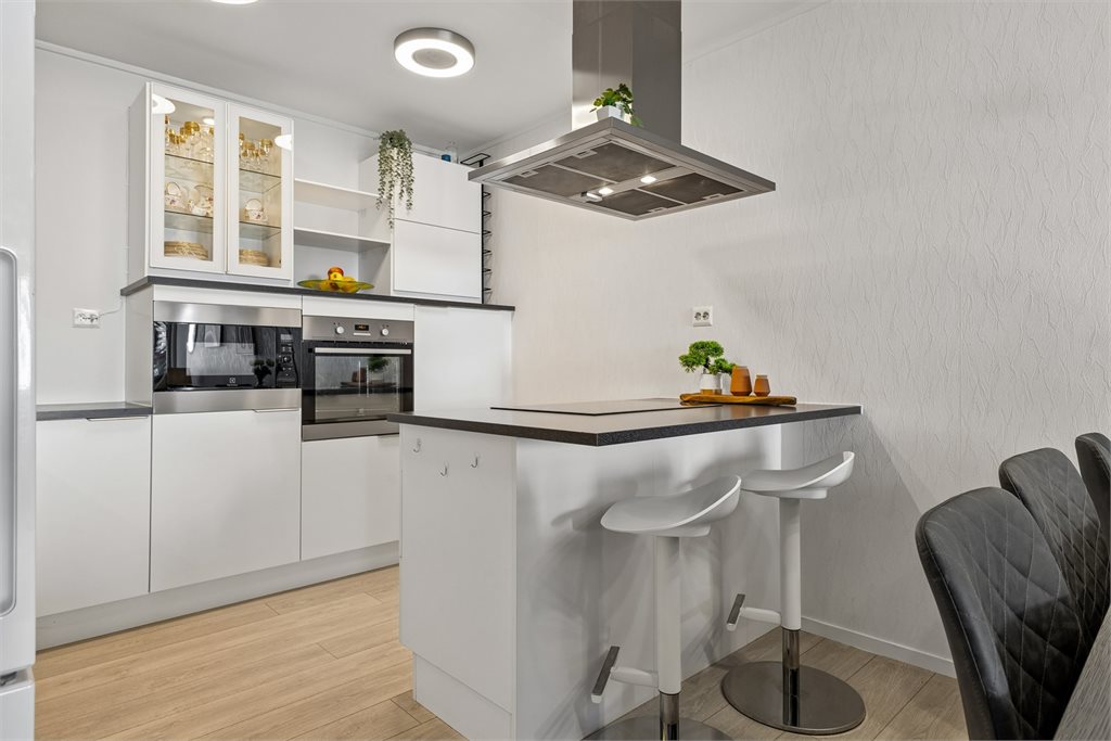 Kjøkkenet har moderne innredning med glatte fronter, godt med skap- og benkeplass samt integrerte hvitevarer.