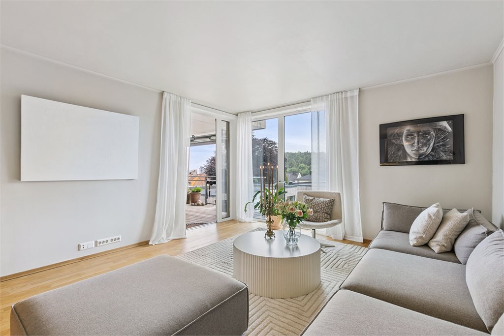 Store vindusflater gir rikelig med naturlig lys. Fra stuen er det flott utsikt og utgang til solrik veranda.