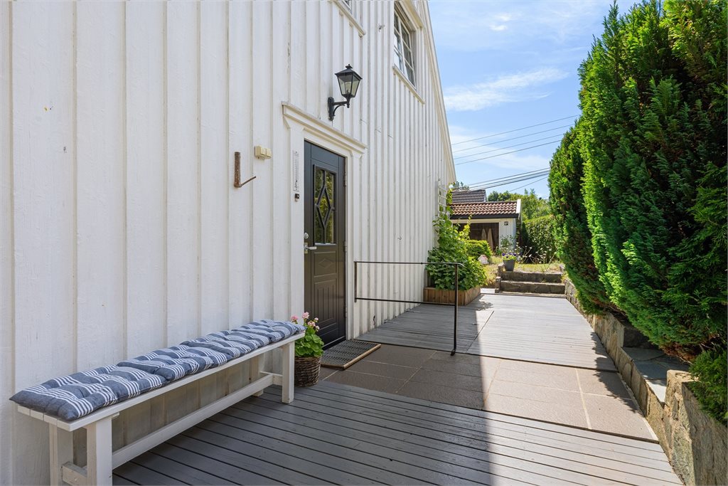Trivelig inngangsparti med terrasse rundt hele huset. Til høyre for inngangsdør er kjellerlem og egen inngang til kjelleren