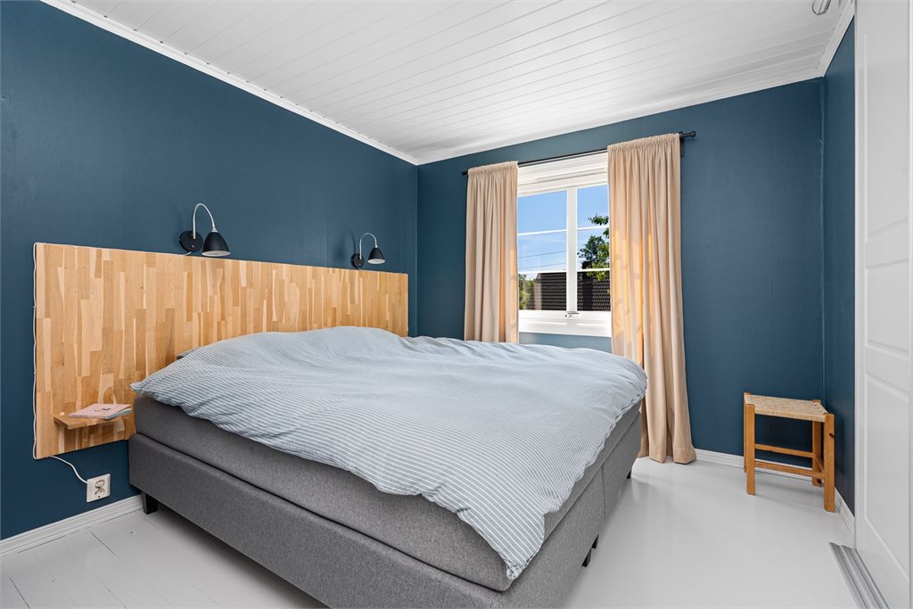 Hovedsoverom med stor skyvedørsgarderobe og inngang til kryploft