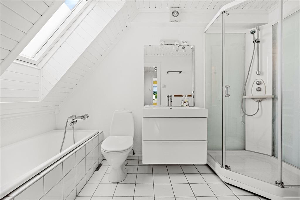 Badet i soveromsetasjen er eldre, men funksjonelt med toalett, stor innredning med servant og skuffer, både dusjkabinett og badekar og plass til mer oppbevaring