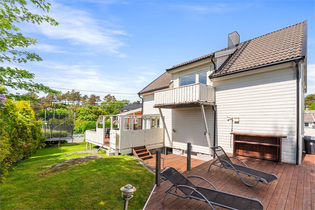 Bakside med terrasse, balkong og pent opparbeidet hage – gode solforhold