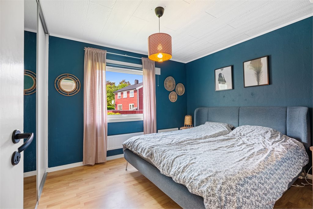 Romslig hovedsoverom med rolige farger, godt lysinnslipp og plass til dobbeltseng