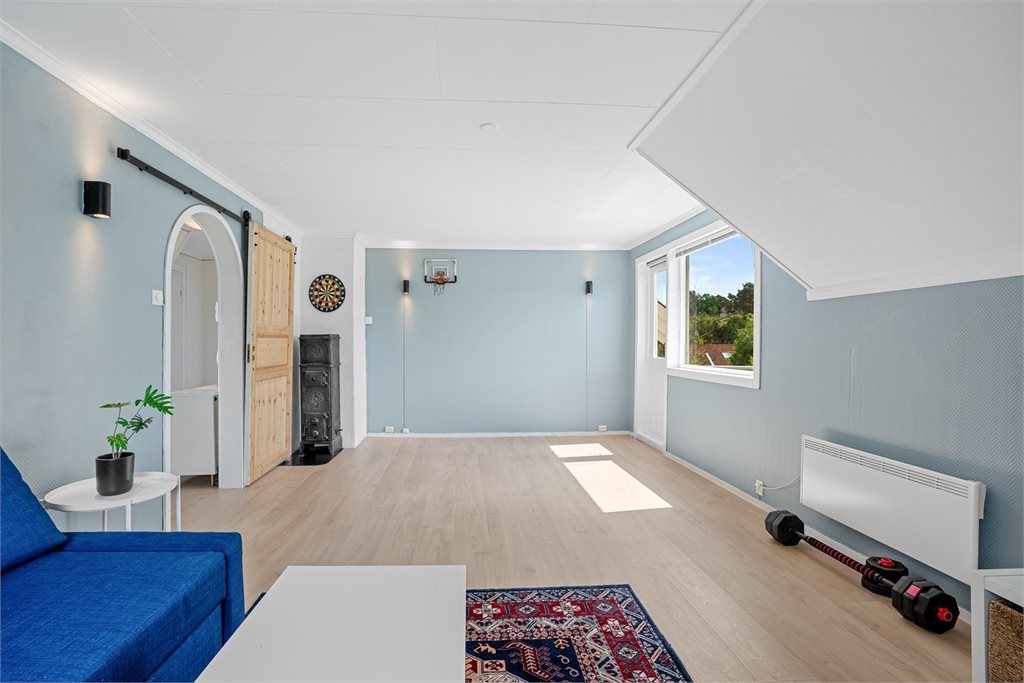 Romslig loftstue/allrom med god takhøyde, lyse flater og fint lysinnslipp