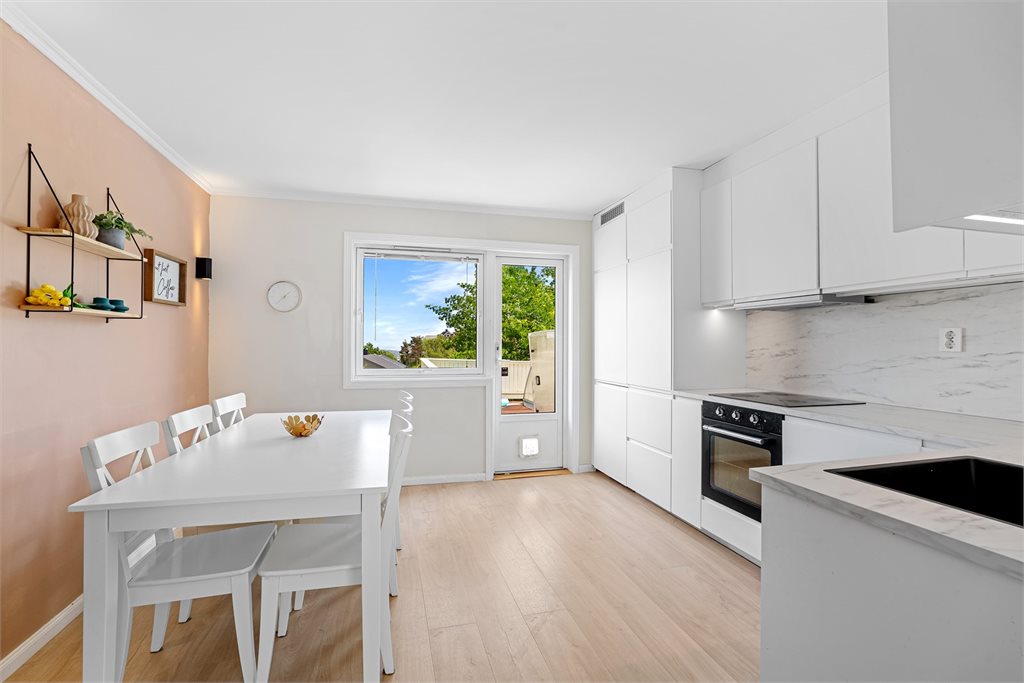 Stilrent kjøkken med spiseplass og utgang til veranda