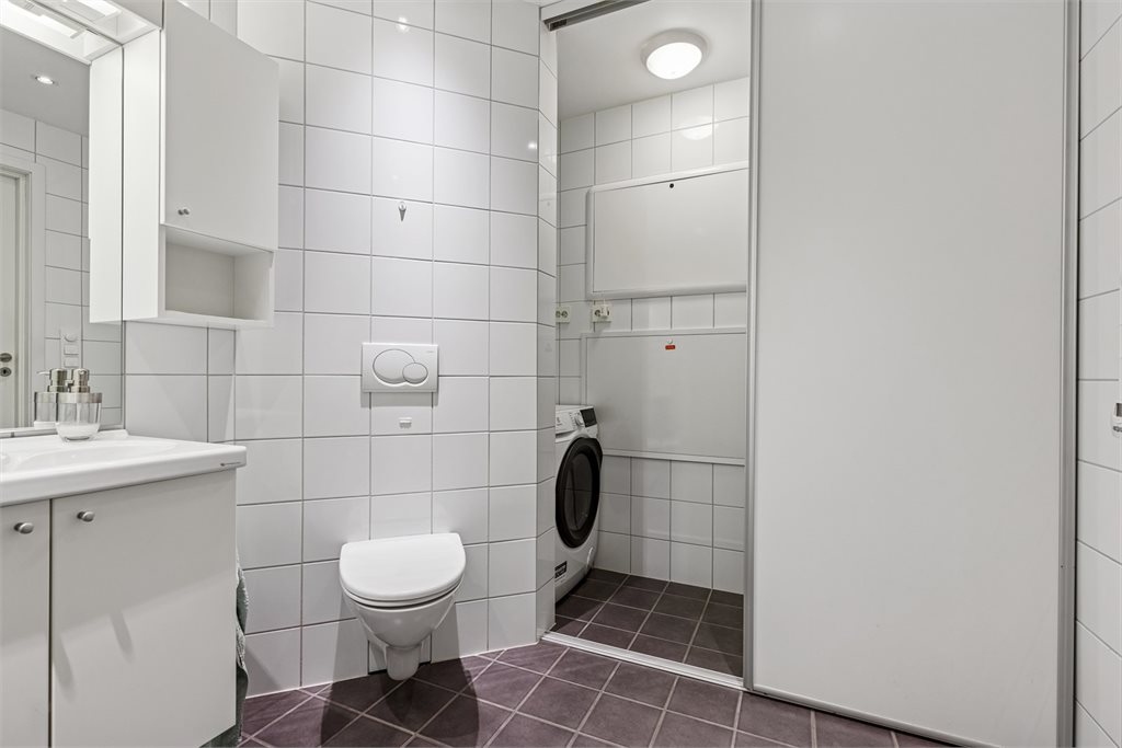 Meget praktisk løsning med skyvedør inn til avgrense del som naturlig brukes til oppbevaring og vaskemaskin.