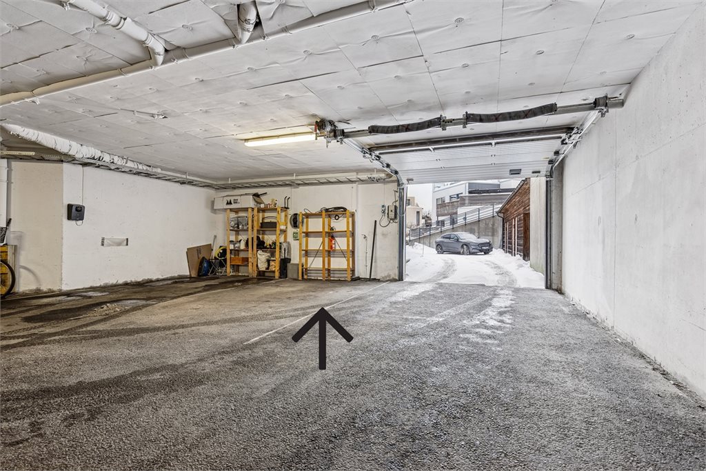 Parkering i lukket anlegg med lader til elbil.