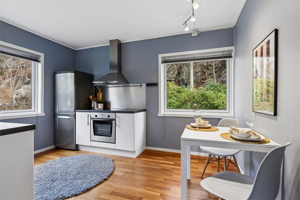 Funksjonelt kjøkken med spiseplass ved vindu